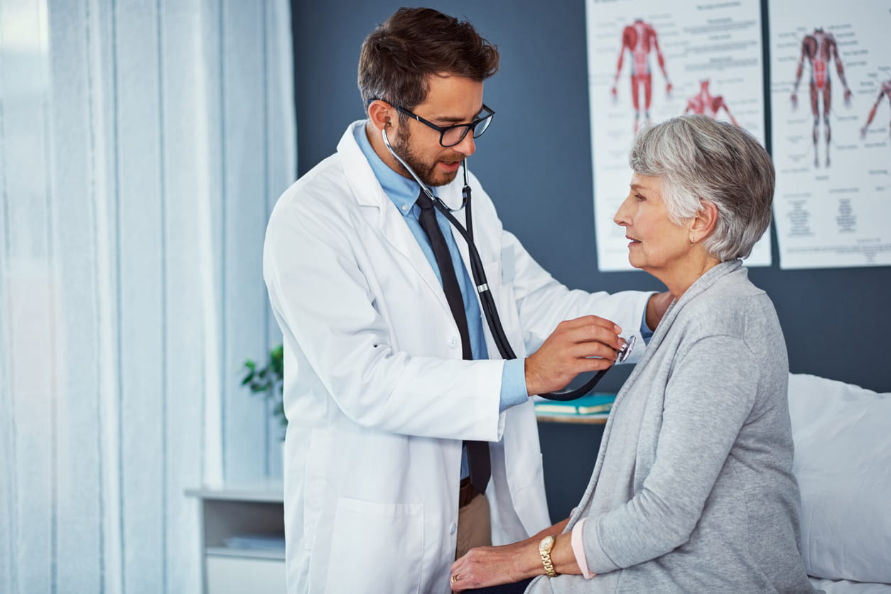 Doctor using stethoscope to listen to patient's heart
